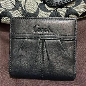 Small blackcoach wallet has pocket for change with zipper